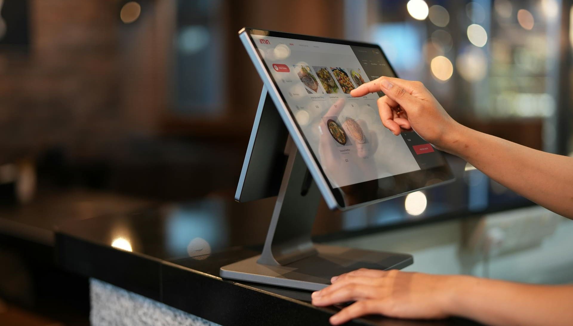 Empleado trabajando con software de gestión de pedidos en un bar